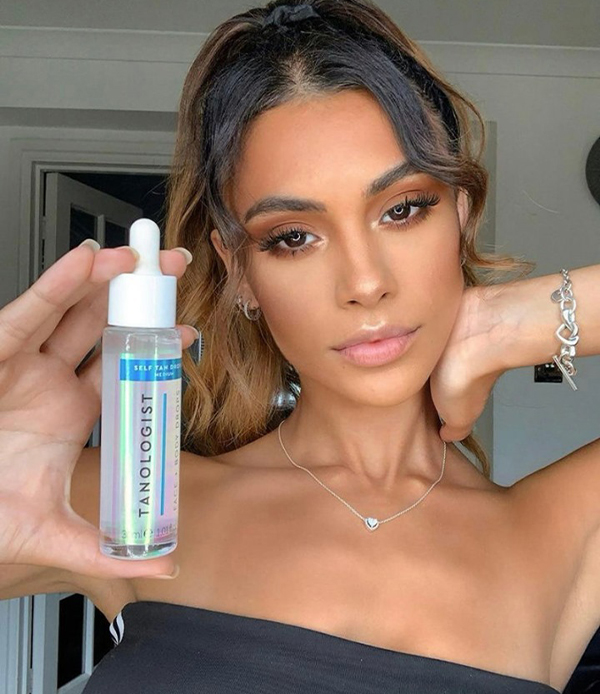 model sitting on sofa wearing dark self tanning water